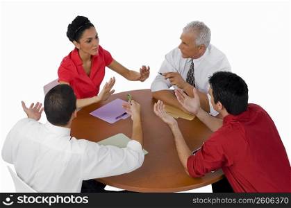 High angle view of three businessmen and a businesswoman discussing in a meeting