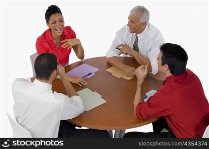 High angle view of three businessmen and a businesswoman laughing in a meeting