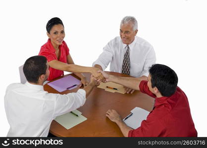 High angle view of three businessmen and a businesswoman shaking hands