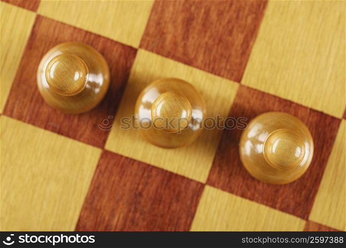 High angle view of three chess pieces on a chessboard