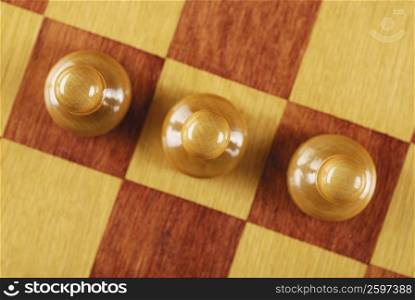 High angle view of three chess pieces on a chessboard