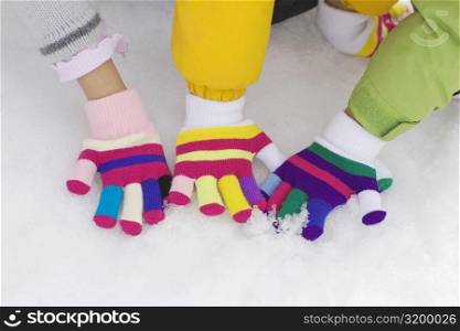 High angle view of three children playing in snow