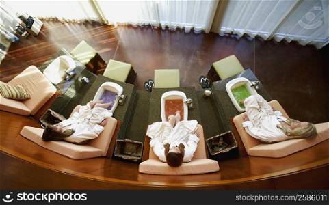High angle view of three mature women getting a pedicure in a beauty parlor