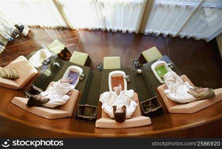 High angle view of three mature women getting a pedicure in a beauty parlor
