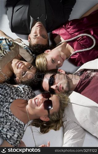 High angle view of three young women with two young men lying on the floor