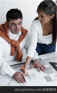 High angle view of two architects working on a blueprint