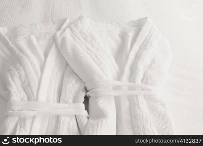 High angle view of two bathrobes on the bed