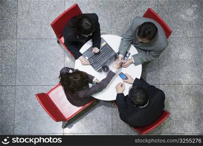 High angle view of two businesswomen with two businessmen in a conference room