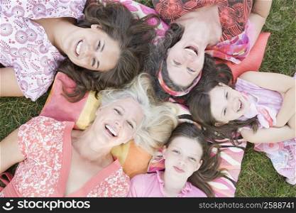 High angle view of two families lying on grass