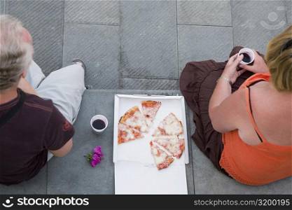 High angle view of two people having pizza, Italian Riviera, Genoa, Liguria, Italy