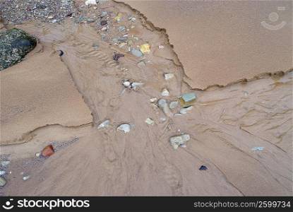 High angle view of water flowing on sand
