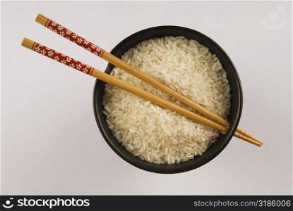High angle view of white rice and chopsticks in a bowl