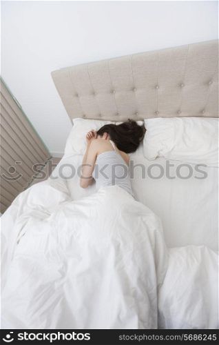 High angle view of woman sleeping in bed