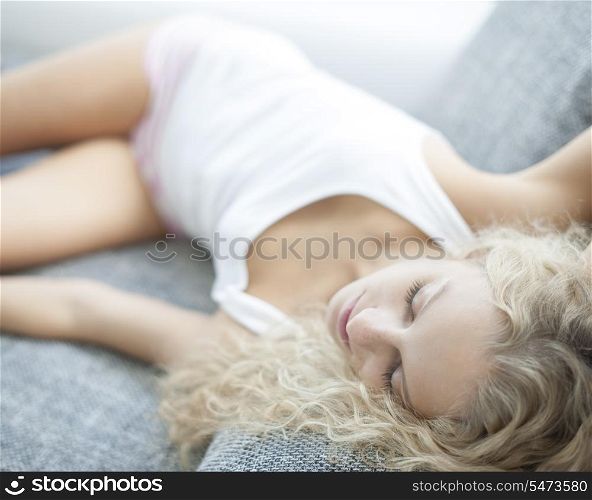 High angle view of woman sleeping on sofa at home