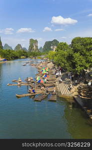 High angle view of wooden rafts at a riverbank with a hill range in the background, Guilin Hills, XingPing, Yangshuo, Guangxi Province, China