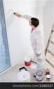 High angle view of workman painting the wall with a roller