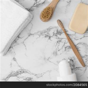 high angle view towels brush soap cosmetic bottle marble surface