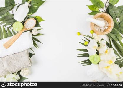 high angle view towels salt candles flowers leaves whit surface
