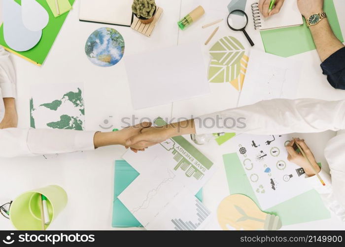 high angle view two businesspeople shaking hands desk