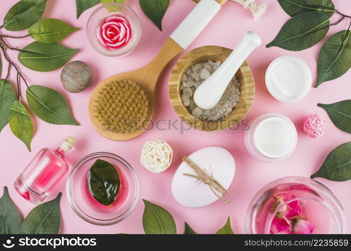 high angle view various spa products green leaves pink background