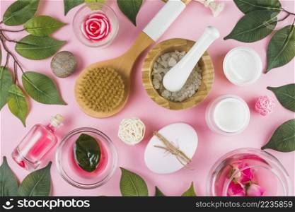 high angle view various spa products green leaves pink background