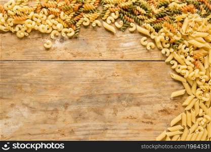 high angle view various types uncooked pasta wooden desk. High resolution photo. high angle view various types uncooked pasta wooden desk. High quality photo