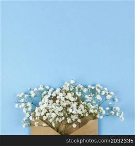 high angle view white baby s breath flowers with brown envelop against blue background