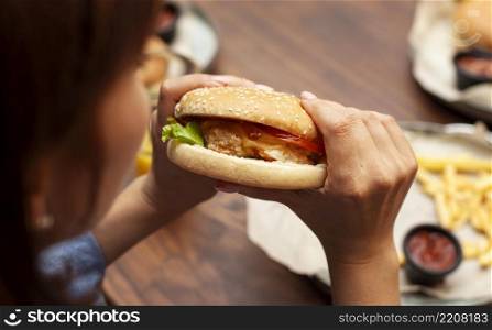high angle woman eating burger