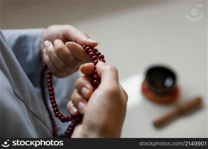 high angle woman holding beads meditating