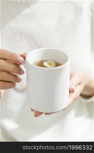 high angle woman holding white mug with tea