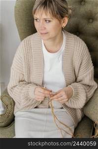 high angle woman knitting inside