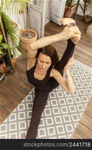 high angle woman stretching mat