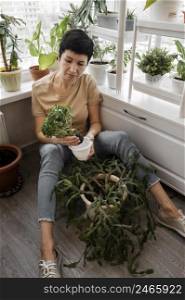 high angle woman taking care indoor plants