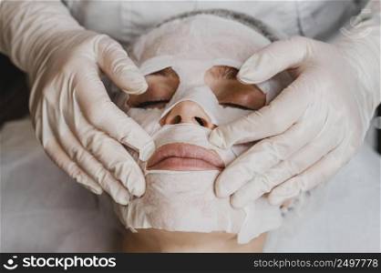 high angle young beautiful woman getting skin mask treatment