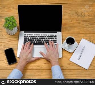 High angled view of male hands typing on computer keyboard on desktop.