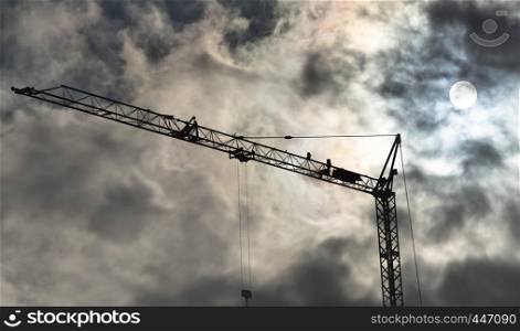 High black construction crane in front of a dramatic threatening sky with translucent sun behind the clouds, germany