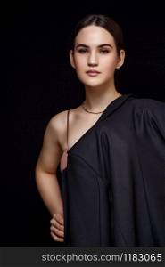 High fashion portrait of young elegant woman in black suit and beige top. Studio shot. on a black isolated background
