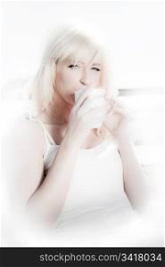 high key image of a beautiful blonde woman having coffee in a restaurant