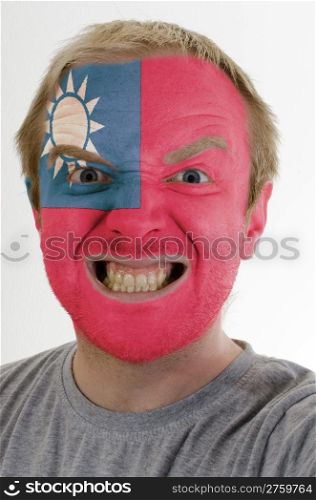 High key portrait of an angry man whose face is painted in colors of taiwan flag