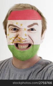 High key portrait of an angry man whose face is painted in colors of tajikistan flag