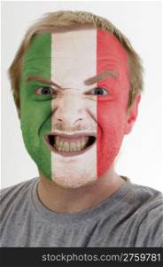 High key portrait of an angry man whose face is painted in colors of italy flag