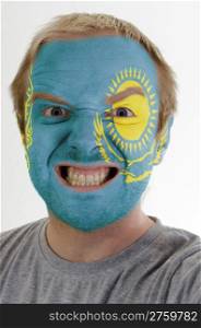 High key portrait of an angry man whose face is painted in colors of kazakstan flag