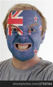 High key portrait of an angry man whose face is painted in colors of new zealand flag
