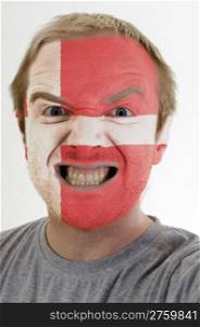 High key portrait of an angry man whose face is painted in colors of denmark flag