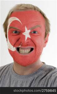 High key portrait of an angry man whose face is painted in colors of turkish flag