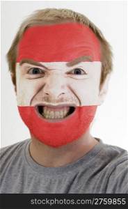 High key portrait of an angry man whose face is painted in colors of austria flag