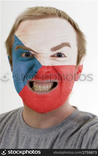 High key portrait of an angry man whose face is painted in colors of czech flag