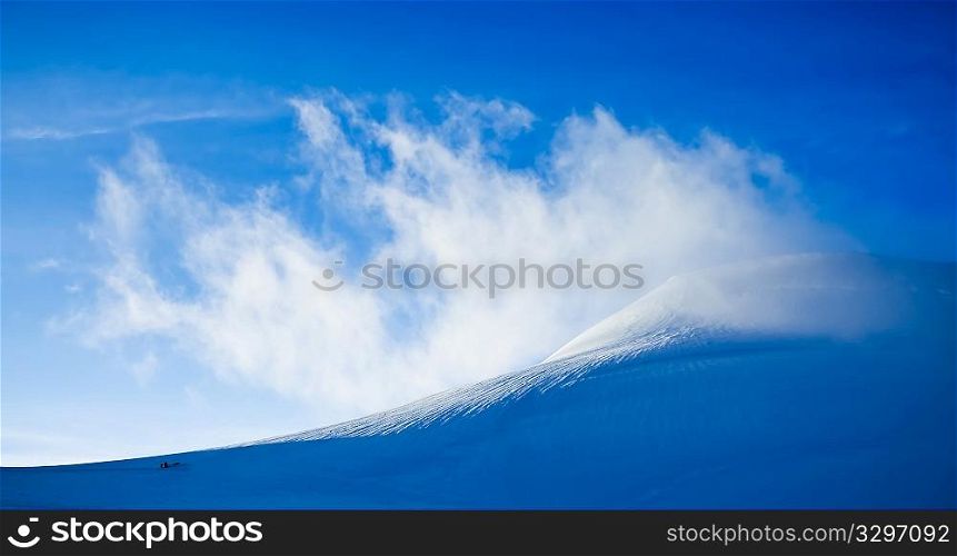 High mountain landscape: glaciers and clouds of Monte Rosa massif (Piramide Vincent), West Alps, Switzerland/Italy. Sunny day, blue sky. Two alpinist in the frame.