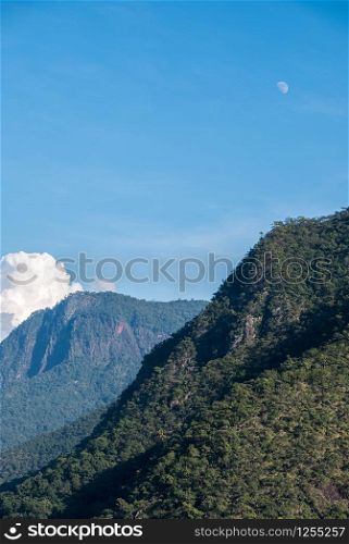 High mountain range with the rain forest in the national park, evening time with the moon