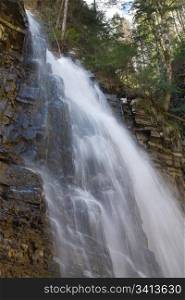 High mountain waterfall in dark wild Carpathian forest (long exposure shooting)